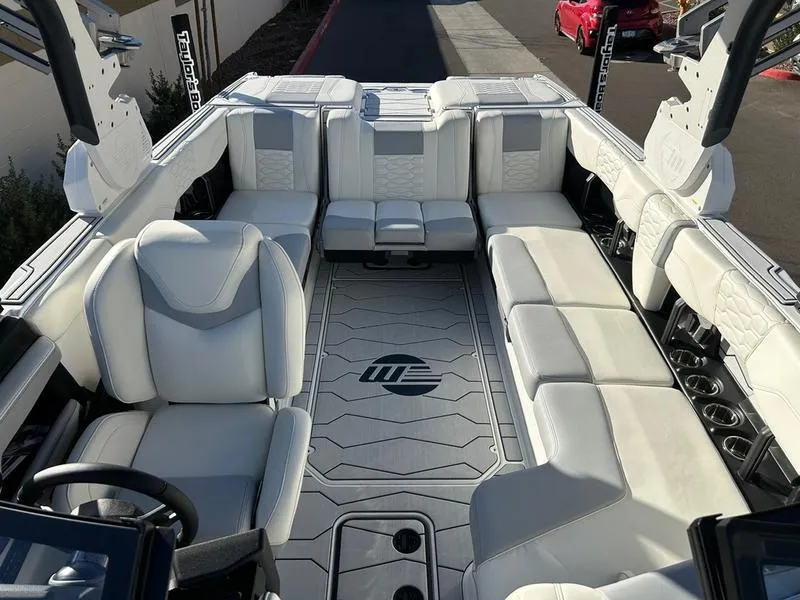Slide: The Image of 2025 Malibu 24 MXZ boat interior with luxurious white seating and modern design. - 15