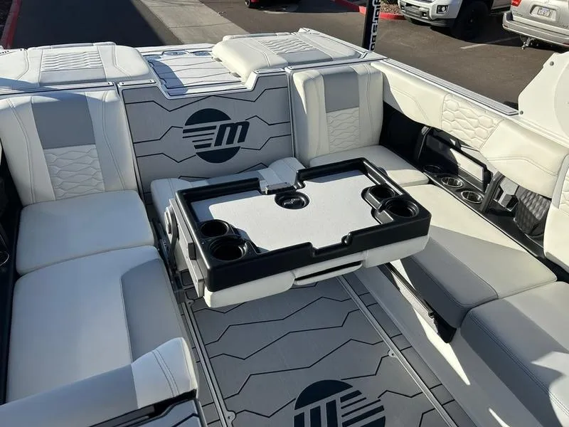 Slide: The Image of 2025 Malibu 24 MXZ boat interior with white seating and a central table. - 19