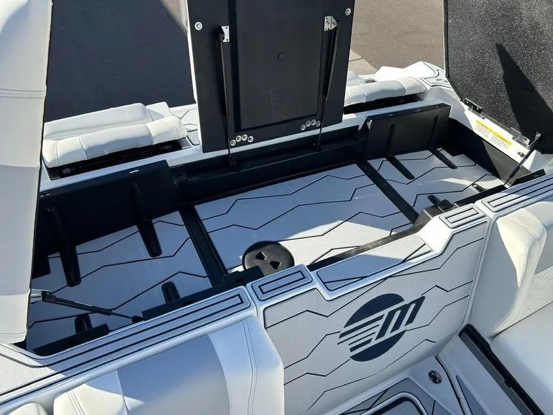 Slide: The Image of 2025 Malibu 24 MXZ boat interior with open storage compartment and sleek design. - 22
