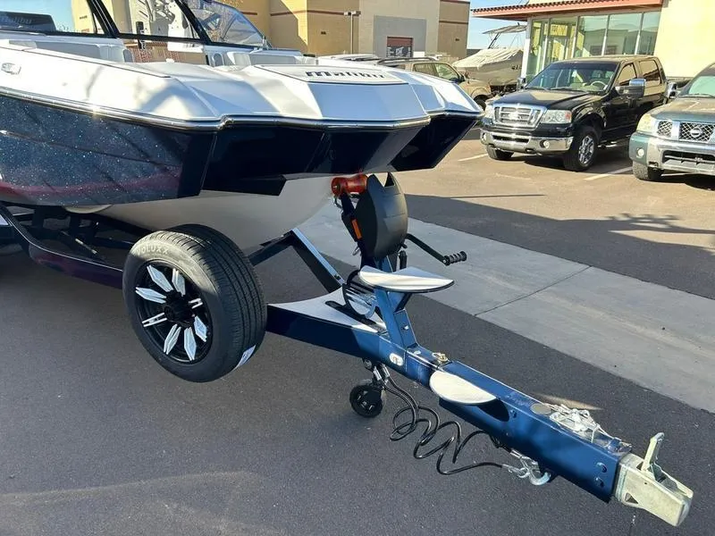 Slide: The Image of 2025 Malibu 24 MXZ boat on trailer in parking lot, rear view. - 8