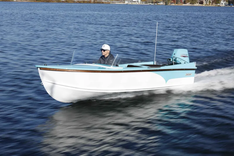 Slide: The Image of 2025 Starcraft 57 SKI CHAMP boat cruising on a serene lake. - 2