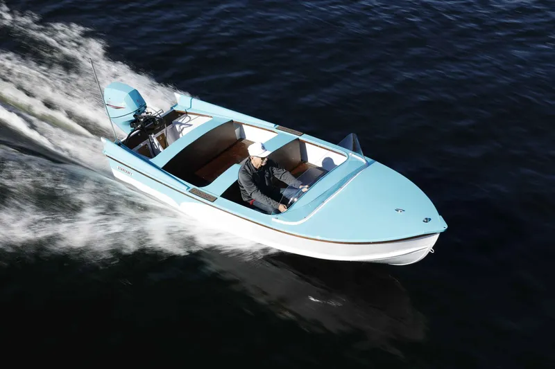 Slide: The Image of A 2025 Starcraft 57 SKI CHAMP boat cruising on water, featuring a sleek blue design. - 5