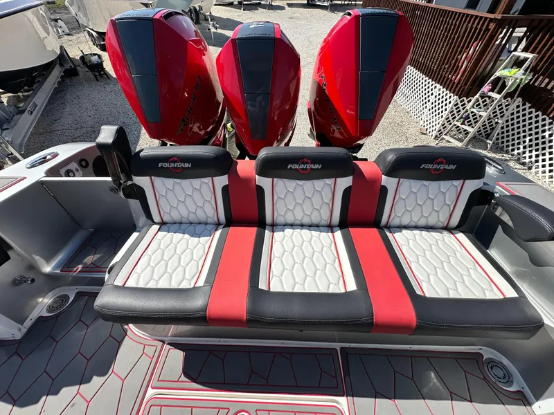 Slide: The Image of 2021 Fountain 38SC boat with red and black seating and triple outboard engines. - 21