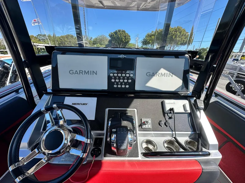 Slide: The Image of 2021 Fountain 38SC boat dashboard with Garmin displays and Mercury controls. - 24