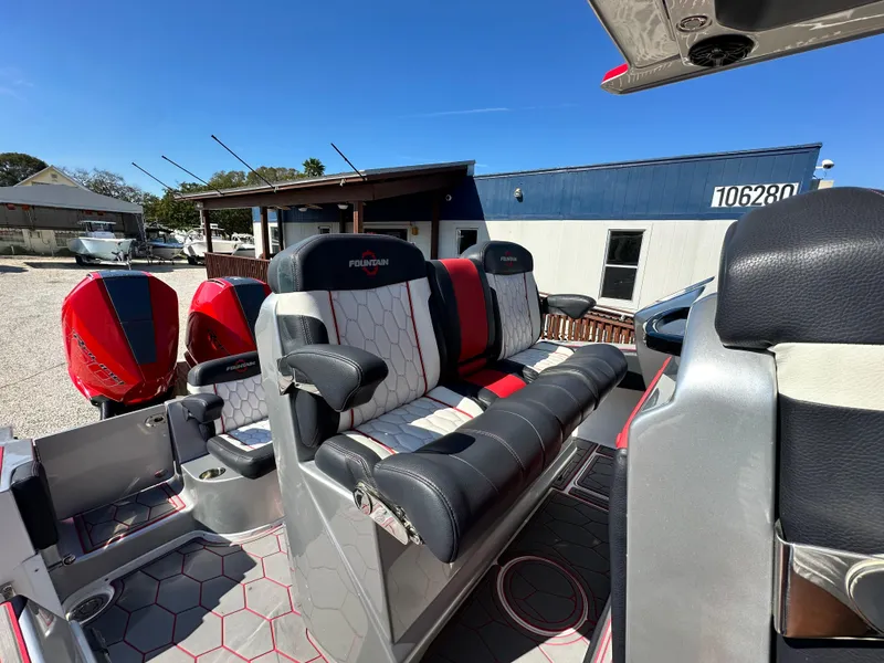 Slide: The Image of 2021 Fountain 38SC boat interior with red and black seating, outdoor setting. - 30
