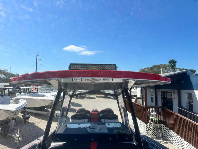 Slide: The Image of 2021 Fountain 38SC boat with red accents, parked outdoors under a clear blue sky. - 32