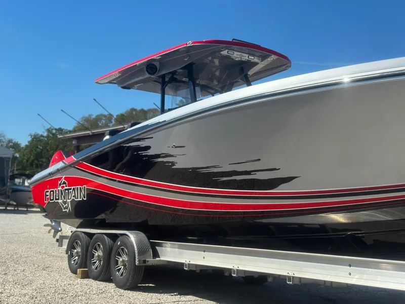 Slide: The Image of 2021 Fountain 38SC boat on trailer, sleek black and red design, sunny day. - 8