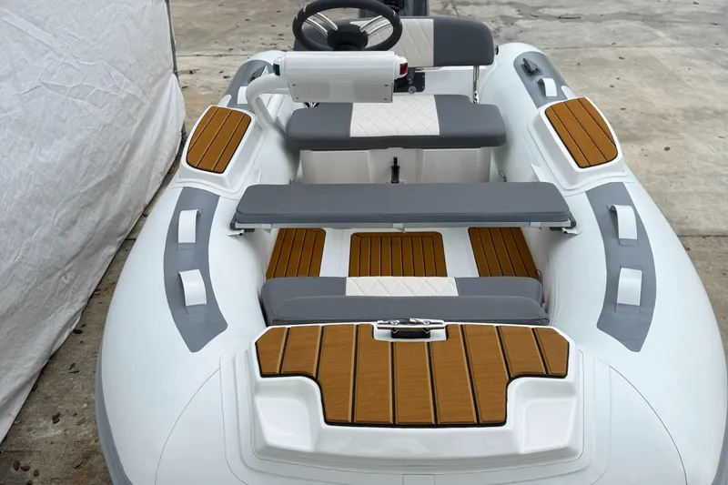 Slide: The Image of 2025 Gala A300Q boat interior with gray and wood accents, featuring a steering wheel and seating. - 7