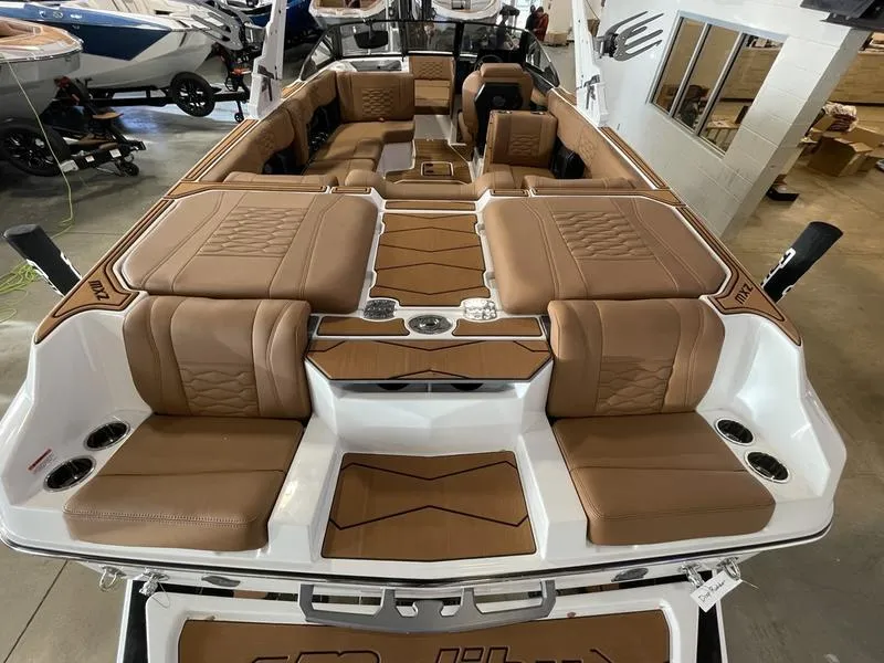 Slide: The Image of 2025 Malibu 24 MXZ boat interior with luxurious brown seating and modern design. - 12