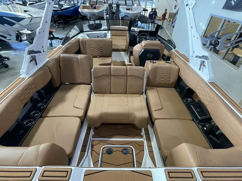Slide: The Image of 2025 Malibu 24 MXZ boat interior with luxurious tan seating and modern design. - 25