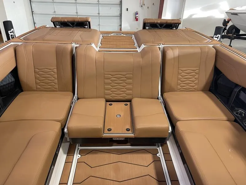 Slide: The Image of 2025 Malibu 24 MXZ boat interior with tan leather seating and modern design. - 26