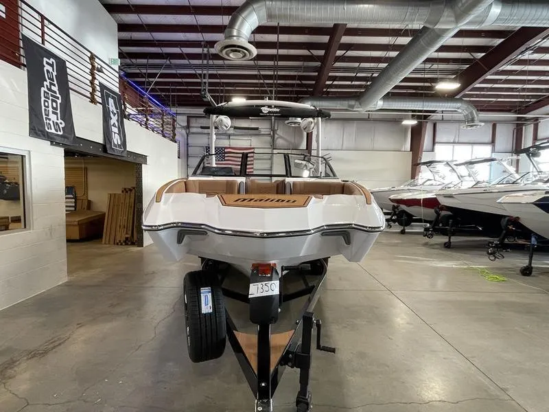 Slide: The Image of 2025 Malibu 24 MXZ boat in showroom, rear view, on trailer. - 6