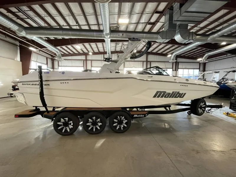 Slide: The Image of 2025 Malibu 24 MXZ boat in showroom, side view on trailer. - 7
