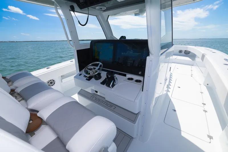 Slide: The Image of 2024 Freeman 47 boat interior with modern helm and seating on open water. - 24