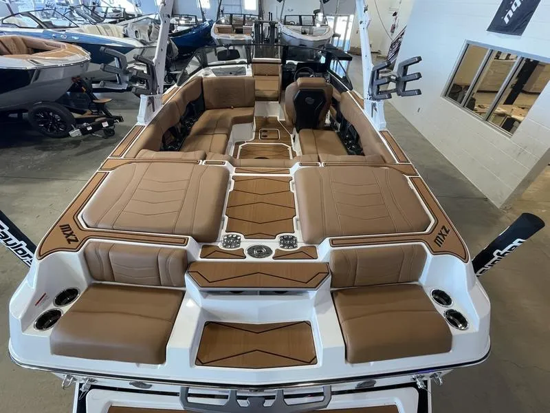 Slide: The Image of 2025 Malibu 22 MXZ boat with luxurious tan seating in showroom. - 10