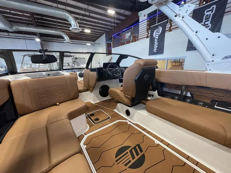 Slide: The Image of 2025 Malibu 22 MXZ boat interior with tan leather seating and modern design. - 13