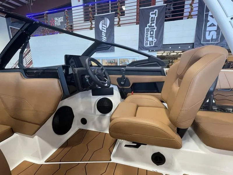 Slide: The Image of 2025 Malibu 22 MXZ boat interior with tan seats and modern dashboard. - 14
