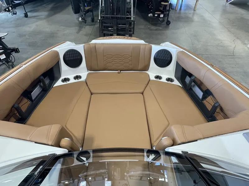 Slide: The Image of 2025 Malibu 22 MXZ boat interior with tan seating and built-in speakers. - 18