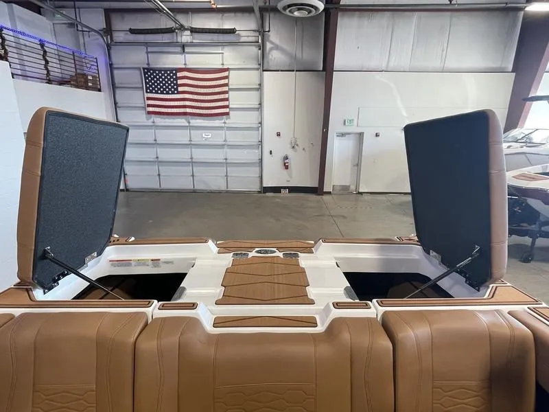 Slide: The Image of 2025 Malibu 22 MXZ boat interior with open storage compartments in a garage setting. - 24