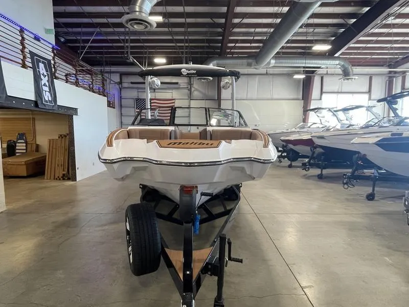 Slide: The Image of 2025 Malibu 22 MXZ boat in showroom, front view, on trailer. - 4