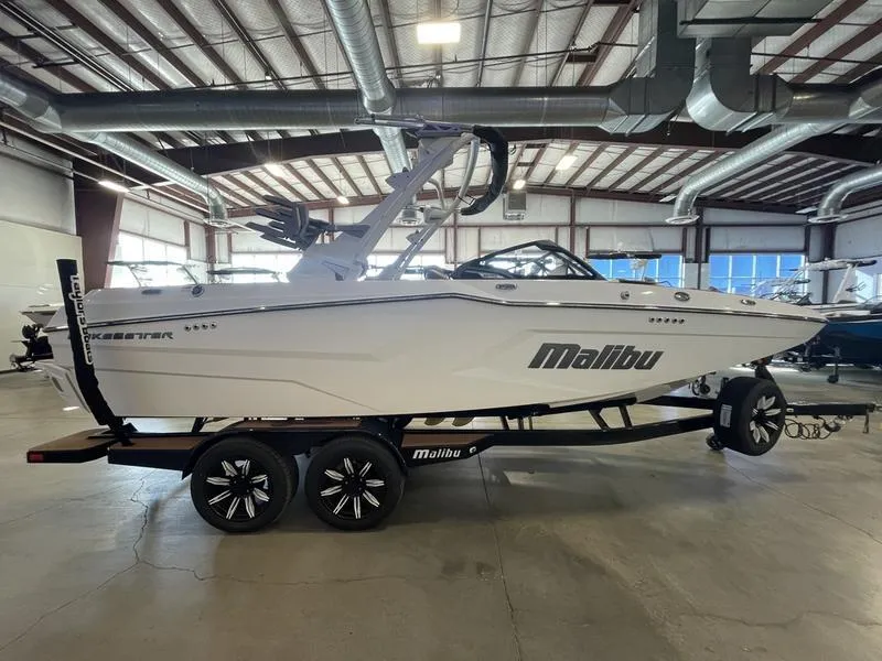 Slide: The Image of 2025 Malibu 22 MXZ boat in showroom, side view on trailer. - 5
