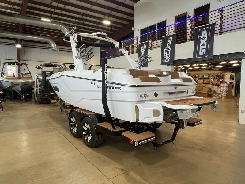 Slide: The Image of 2025 Malibu 22 MXZ boat in showroom, white exterior, on trailer. - 9