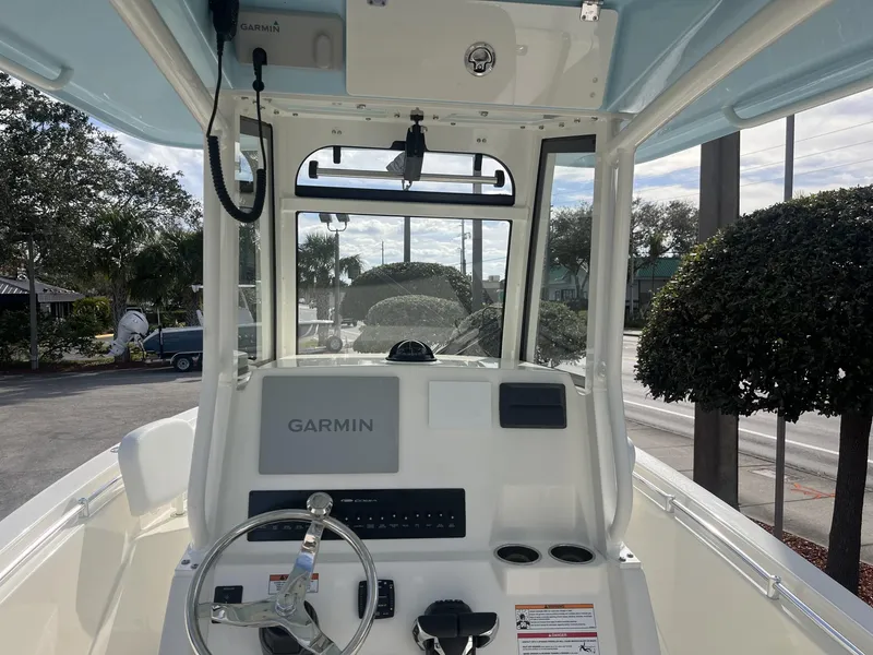 Slide: The Image of 2025 Cobia 240 CC boat console with Garmin navigation system, steering wheel, and cup holders. - 12
