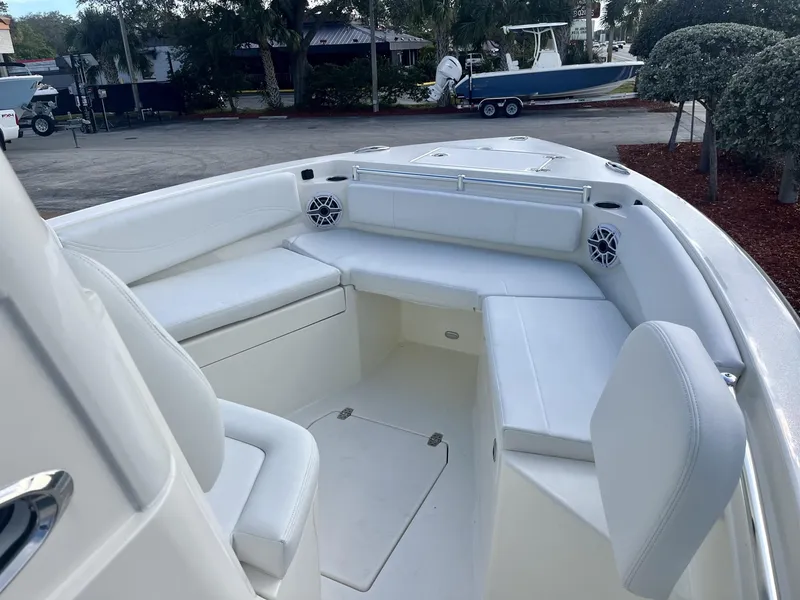 Slide: The Image of 2025 Cobia 240 CC boat interior with white seating and speakers. - 19