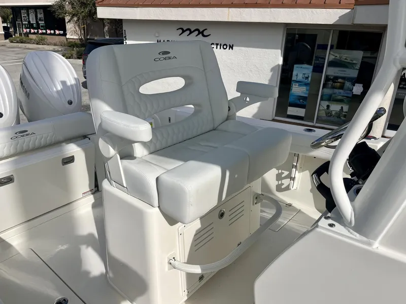 Slide: The Image of 2025 Cobia 240 CC boat interior with white seating and dual Yamaha engines. - 25