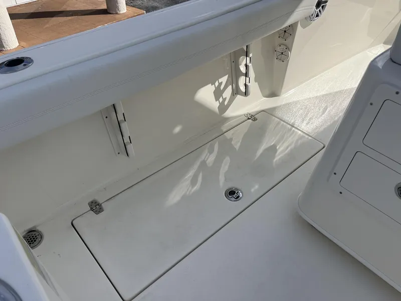 Slide: The Image of 2025 Cobia 240 CC boat interior, featuring clean white deck and storage compartments. - 36