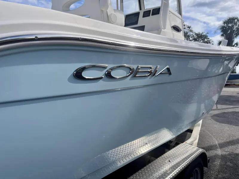 Slide: The Image of 2025 Cobia 240 CC boat on trailer, showcasing sleek design and branding. - 7