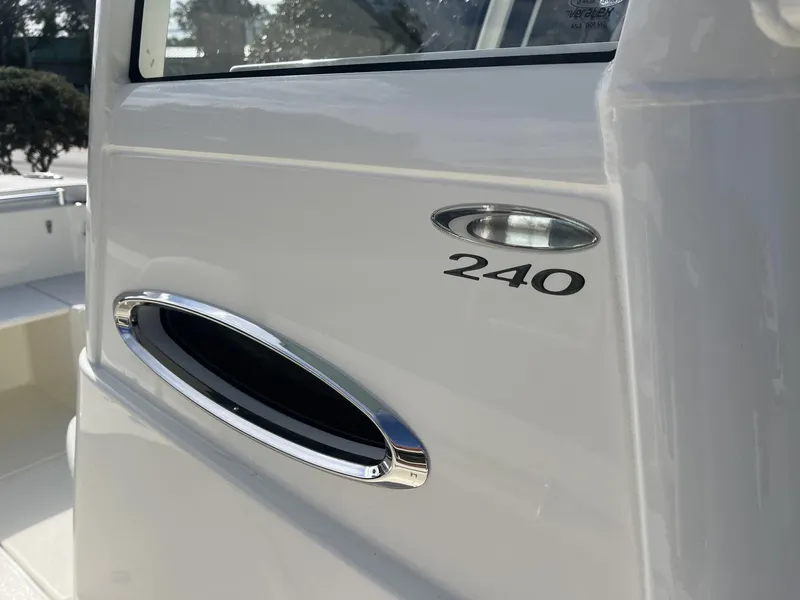 Slide: The Image of 2025 Cobia 240 CC boat detail, showcasing sleek design and chrome accents. - 17