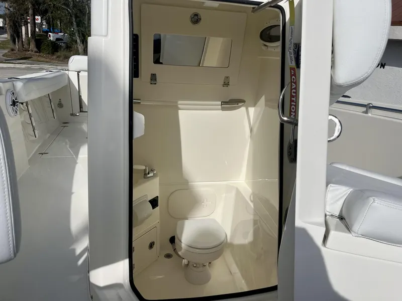 Slide: The Image of 2025 Cobia 240 CC boat interior with compact bathroom and toilet. - 23