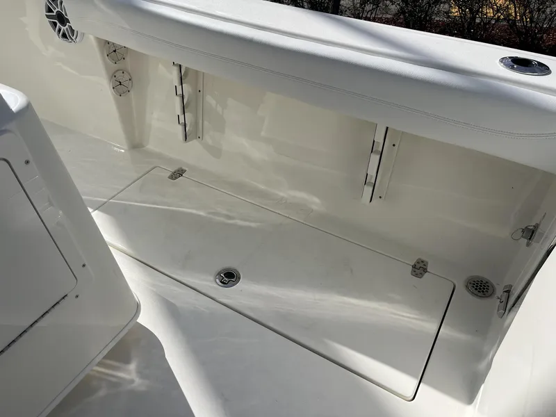 Slide: The Image of 2025 Cobia 240 CC boat interior, featuring white seating and storage compartments. - 35