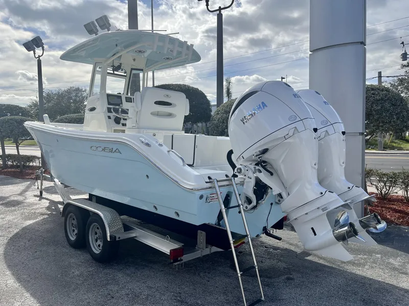 Slide: The Image of 2025 Cobia 240 CC boat with twin Yamaha engines on a trailer. - 4