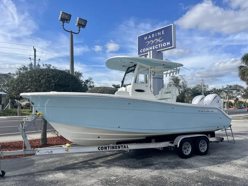 Slide: The Image of 2025 Cobia 240 CC boat on trailer at Marine Connection dealership. - 1
