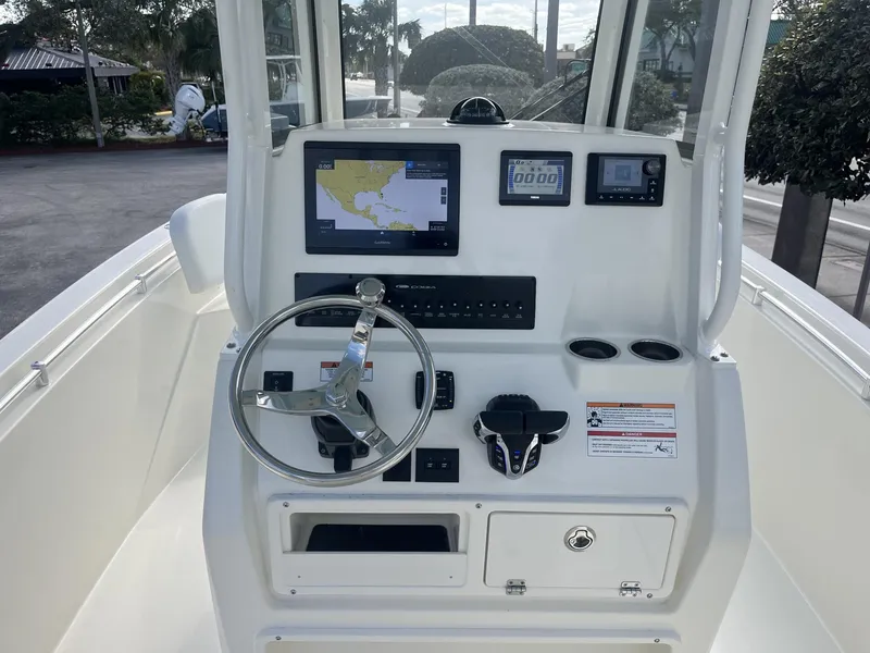 Slide: The Image of 2025 Cobia 240 CC boat dashboard with navigation and control systems. - 13