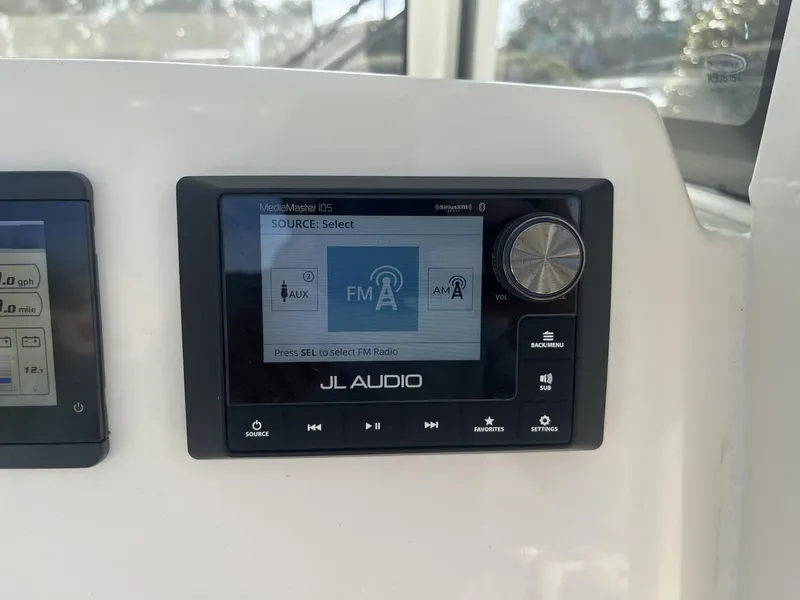 Slide: The Image of JL Audio MediaMaster display on 2025 Cobia 240 CC boat dashboard. - 15