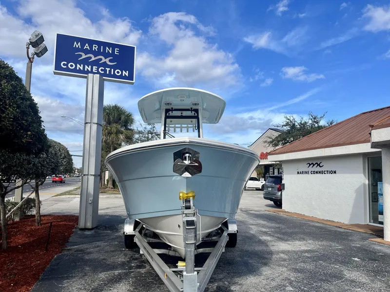 Slide: The Image of 2025 Cobia 240 CC boat at Marine Connection dealership under blue sky. - 3