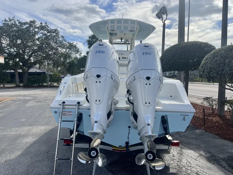 Slide: The Image of 2025 Cobia 240 CC boat with dual 150 horsepower engines, parked outdoors. - 5