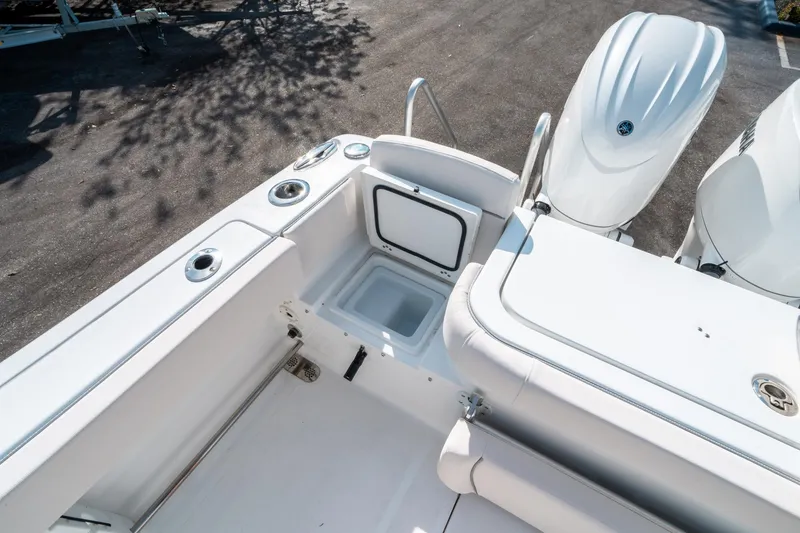 Slide: The Image of 2025 Sea Hunt GAMEFISH 27 CB boat interior with open storage compartment and dual engines. - 16