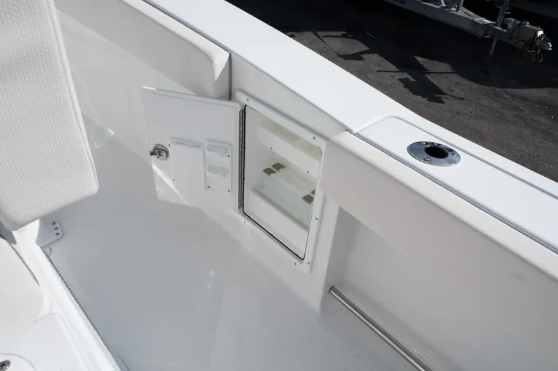 Slide: The Image of 2025 Sea Hunt GAMEFISH 27 CB boat interior with storage compartment and rod holder. - 19