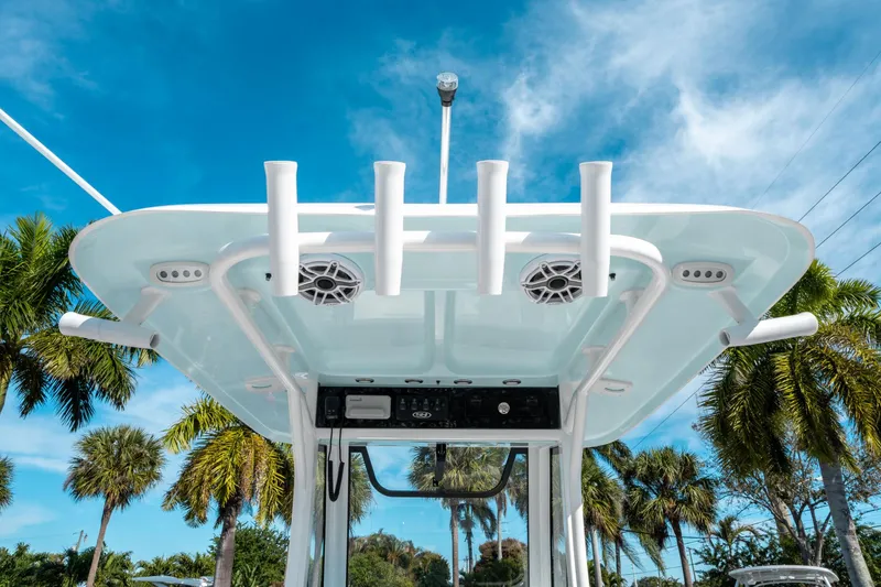 Slide: The Image of 2025 Sea Hunt GAMEFISH 27 CB boat with rod holders and speakers, under a clear blue sky. - 21