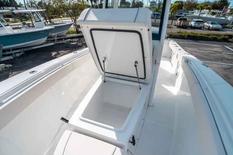 Slide: The Image of 2025 Sea Hunt GAMEFISH 27 CB boat with open storage compartment, parked outdoors. - 39