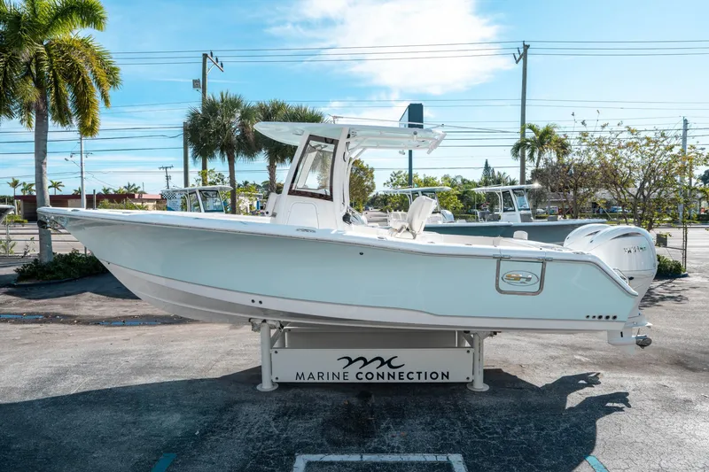 Slide: The Image of 2025 Sea Hunt GAMEFISH 27 CB boat displayed outdoors on a stand. - 5