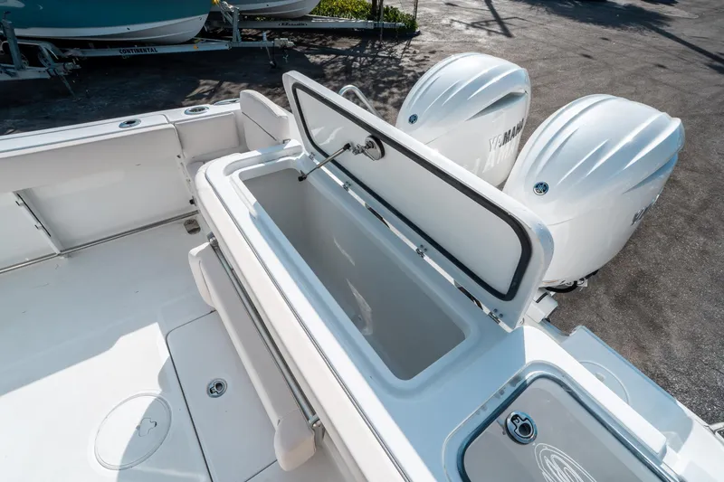 Slide: The Image of 2025 Sea Hunt GAMEFISH 27 CB boat with open storage compartment and dual Yamaha engines. - 14