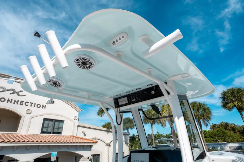 Slide: The Image of 2025 Sea Hunt GAMEFISH 27 CB boat with T-top and rod holders under a clear blue sky. - 22
