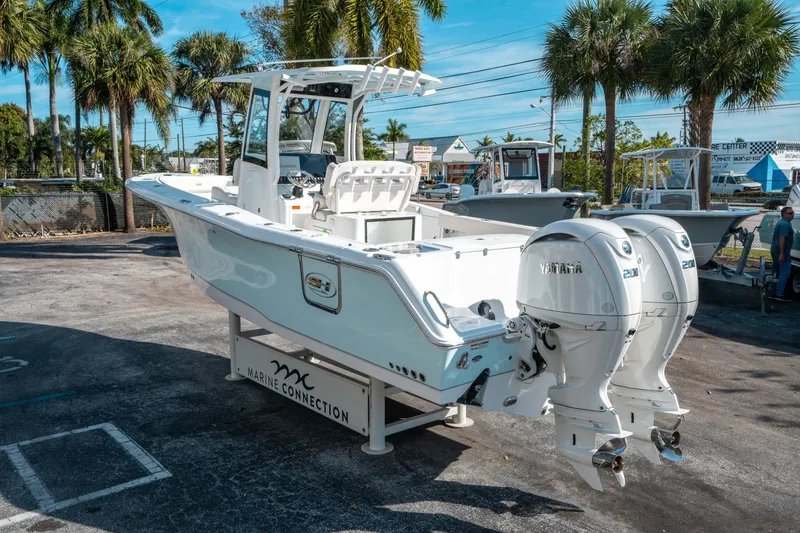Slide: The Image of 2025 Sea Hunt GAMEFISH 27 CB boat with twin Yamaha engines, displayed outdoors. - 4