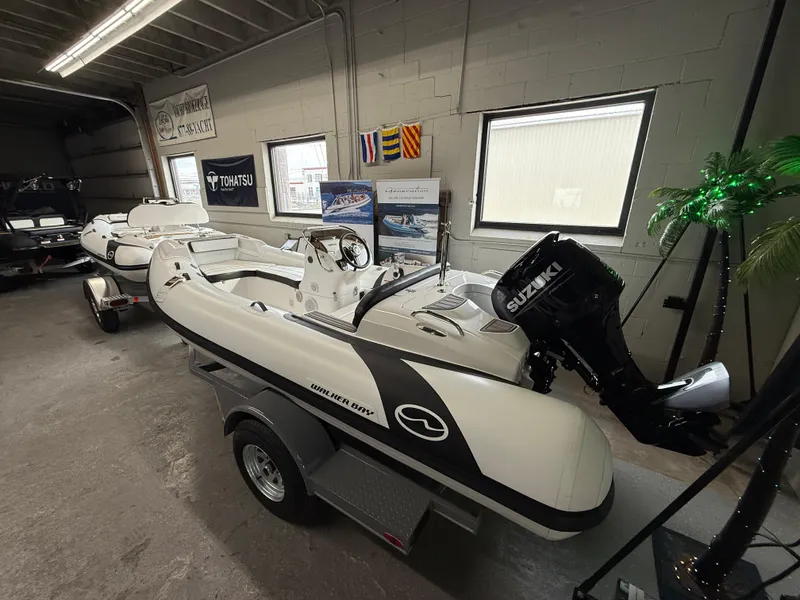 Slide: The Image of 2025 Walker Bay Generation 450 DLX boat with Suzuki engine in showroom. - 0