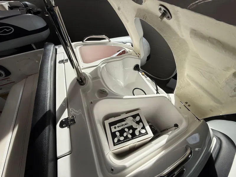 Slide: The Image of 2025 Walker Bay Generation 450 DLX boat interior with open storage compartment and Suzuki control panel. - 12